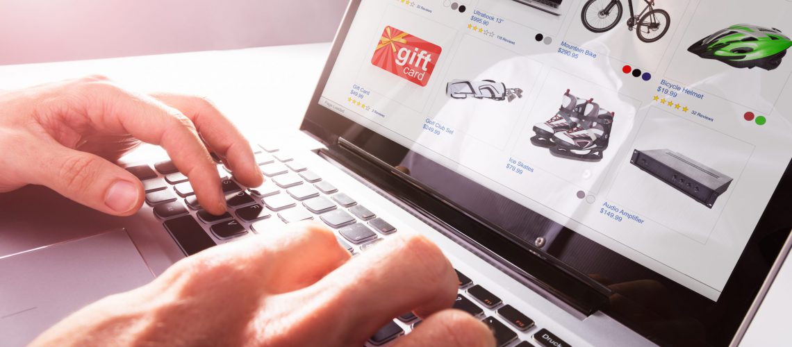 Close-up Of Person Shopping Online On Laptop Over Desk